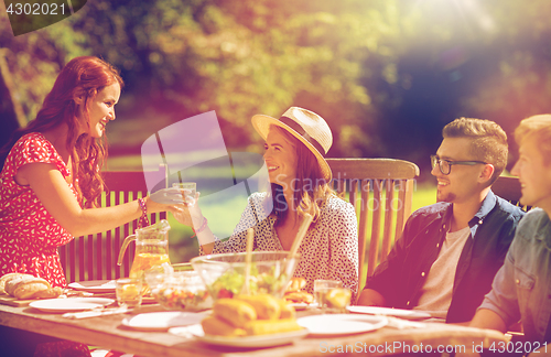 Image of happy friends having dinner at summer garden party