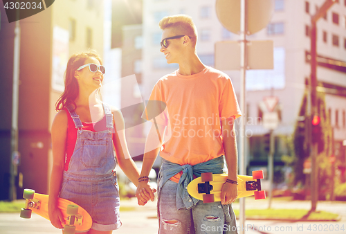 Image of teenage couple with skateboards on city street