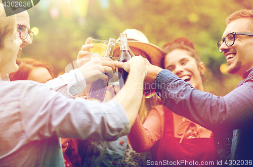 Image of happy friends clinking glasses at summer garden