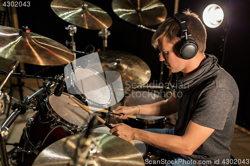 Image of male musician playing drums and cymbals at concert