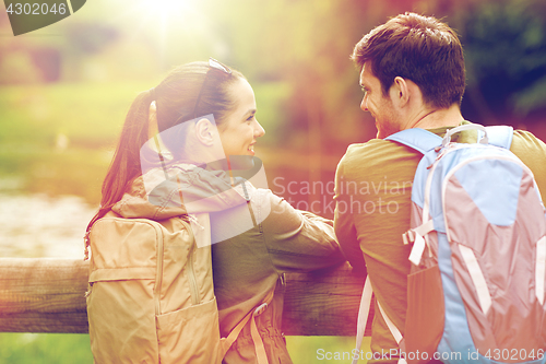 Image of smiling couple with backpacks in nature