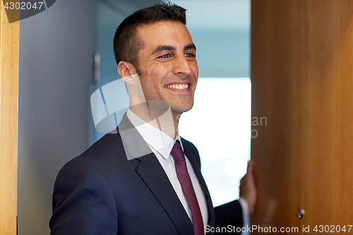 Image of businessman at hotel room or office door