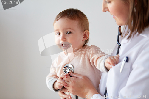 Image of doctor with stethoscope listening baby at clinic