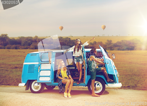 Image of happy hippie friends in minivan car in africa