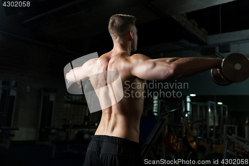 Image of close up of man with dumbbells exercising in gym