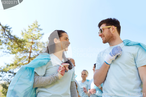 Image of volunteers with garbage bags talking outdoors