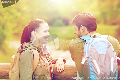 Image of smiling couple with backpacks in nature