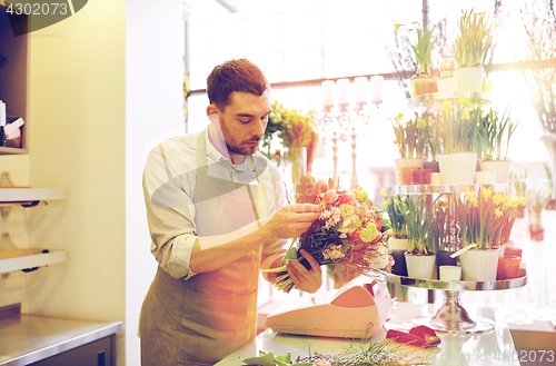 Image of florist man making bunch at flower shop