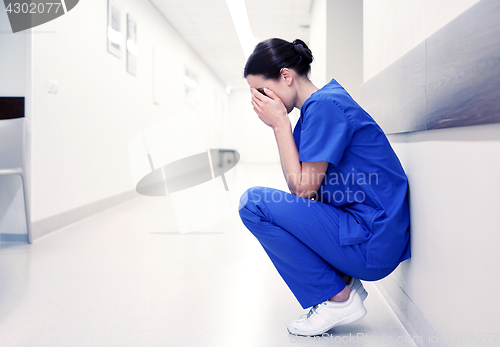 Image of sad or crying female nurse at hospital corridor