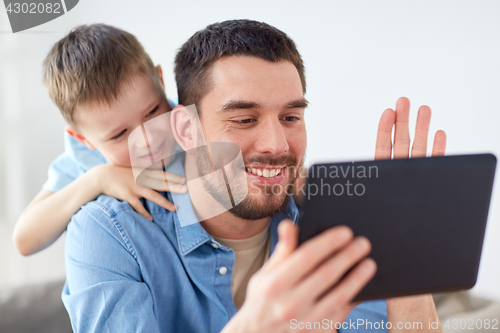 Image of father and son with tablet pc having video chat
