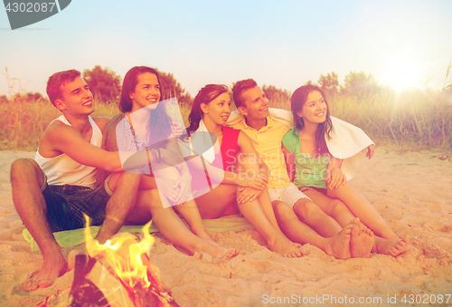 Image of smiling friends in sunglasses on summer beach