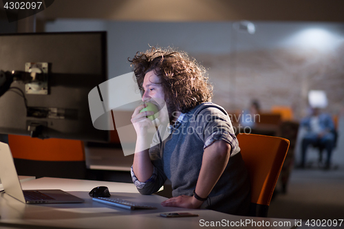 Image of man eating apple in his office