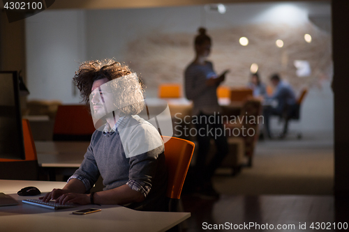 Image of man working on computer in dark office