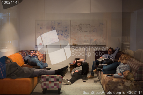 Image of software developers sleeping on sofa in creative startup office
