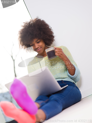 Image of black woman in the living room on the floor