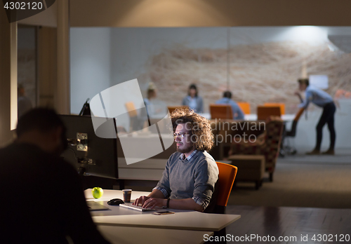 Image of man working on computer in dark office