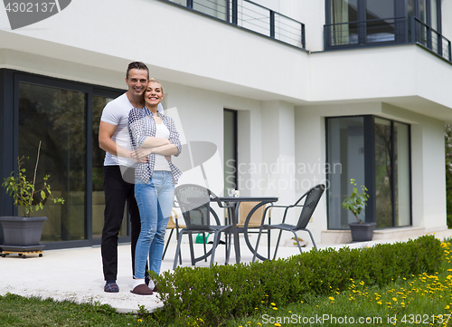 Image of couple hugging in front of  new luxury home