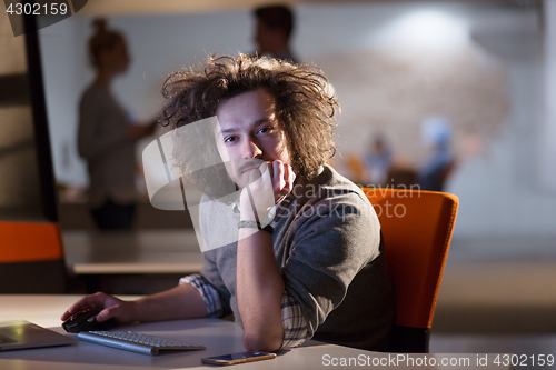 Image of man working on computer in dark office