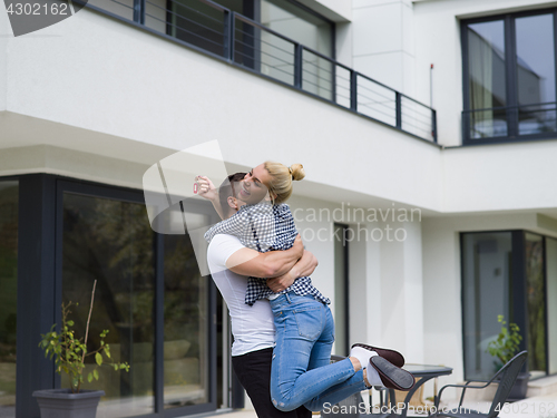 Image of couple hugging in front of  new luxury home