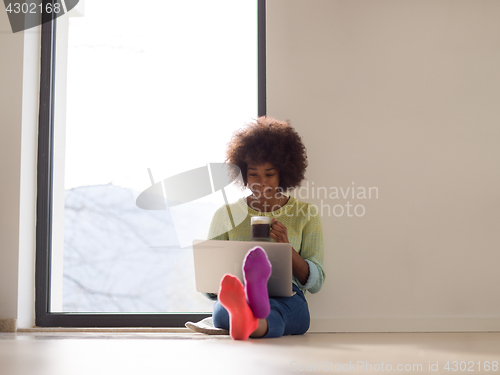 Image of black woman in the living room on the floor