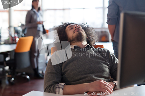 Image of young businessman relaxing at the desk