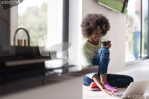 Image of black woman in the living room on the floor