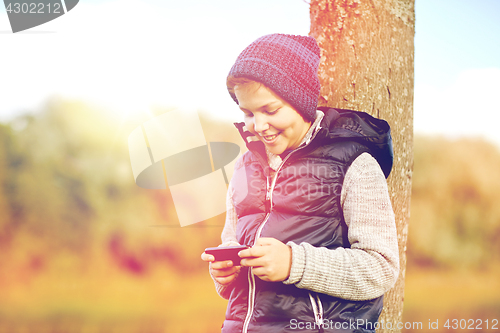 Image of happy boy playing game on smartphone outdoors