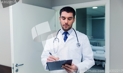 Image of doctor writing to clipboard at hospital