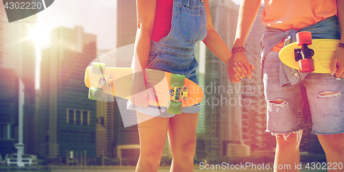 Image of close up of young couple with skateboards in city