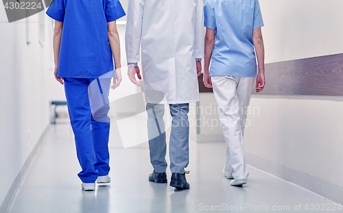 Image of group of medics or doctors walking along hospital