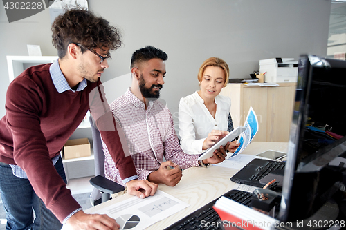 Image of business team with tablet pc and papers in office