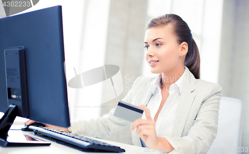 Image of businesswoman with laptop using credit card