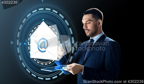 Image of businessman with tablet pc and e-mail hologram