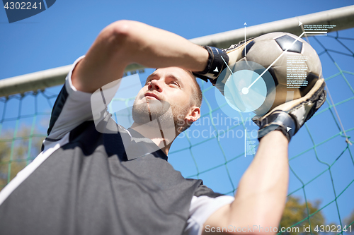 Image of goalkeeper with ball at football goal on field