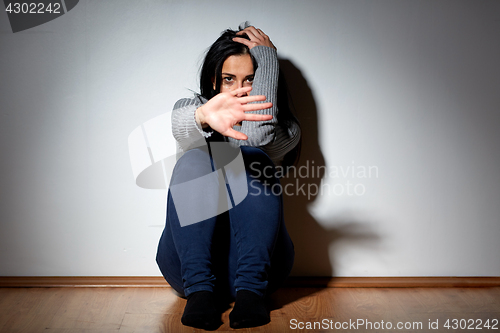 Image of unhappy woman crying on floor at home