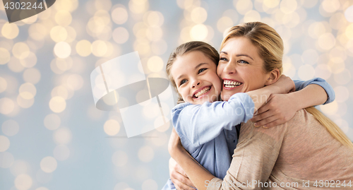 Image of happy girl with mother hugging over lights