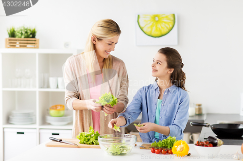 Image of happy family cooking salad at home kitchen
