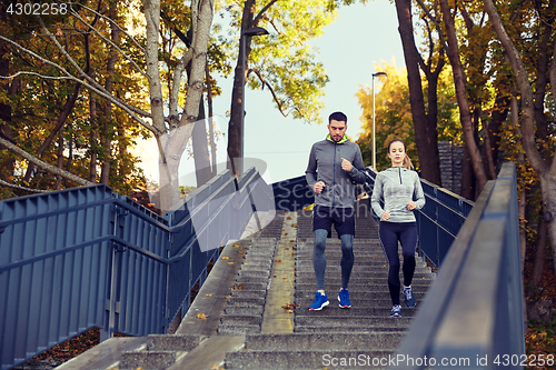 Image of happy couple running downstairs in city