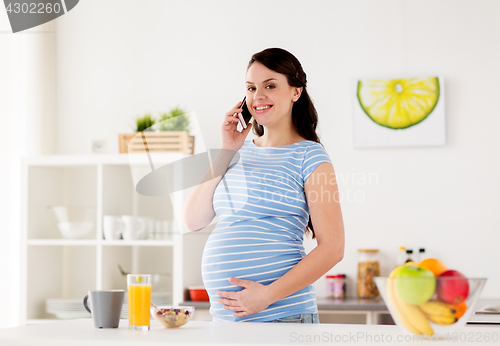 Image of happy pregnant woman calling on smartphone at home