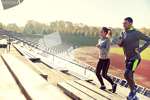 Image of happy couple running upstairs on stadium