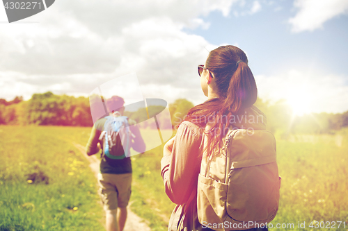 Image of happy couple with backpacks hiking outdoors