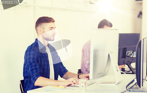 Image of creative man or student with computer at office