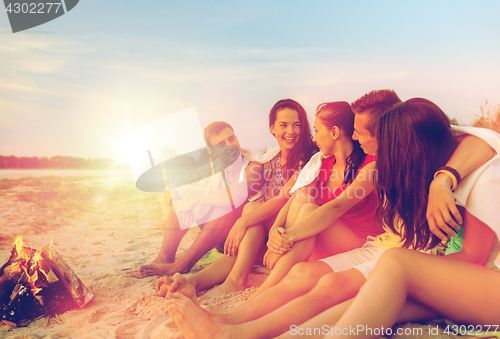 Image of smiling friends in sunglasses on summer beach