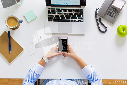 Image of businesswoman with laptop and smartphone at office