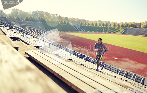 Image of happy young man running upstairs on stadium