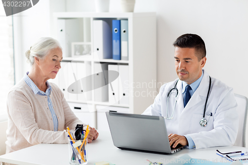 Image of senior woman and doctor with laptop at hospital