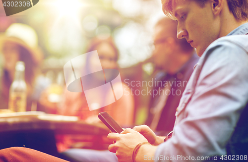 Image of man with smartphone and friends at summer party