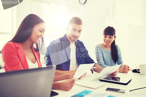 Image of happy creative team or students working at office