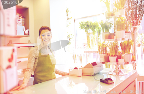 Image of happy smiling florist woman at flower shop counter