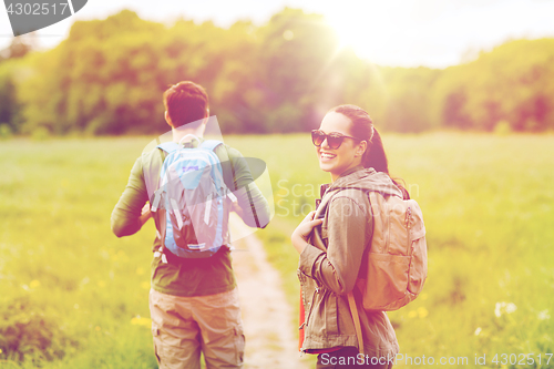 Image of happy couple with backpacks hiking outdoors